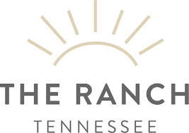 Logo featuring a stylized sun and text for The Ranch in Tennessee.