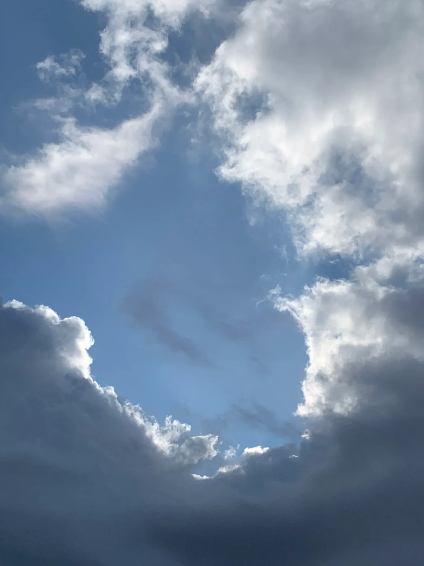 Bright blue sky surrounded by clouds
